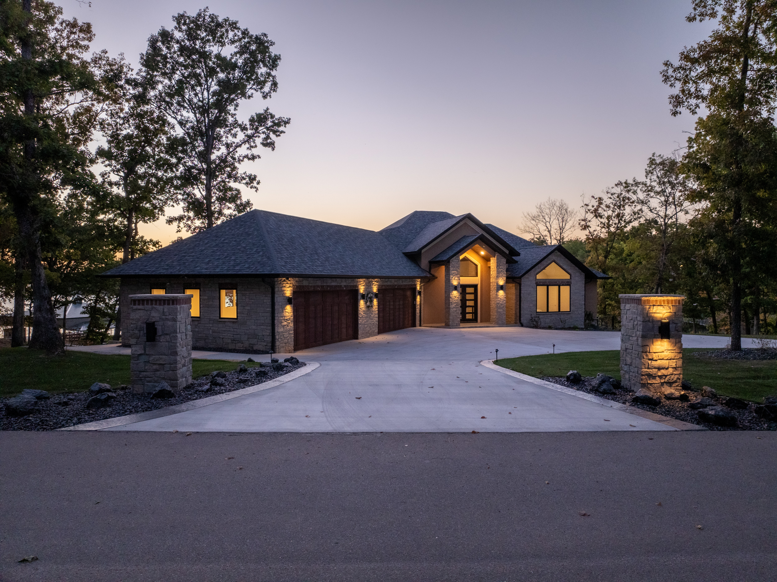 Aerial view of custom lakefront home with infinity pool by Cloke Custom Homes