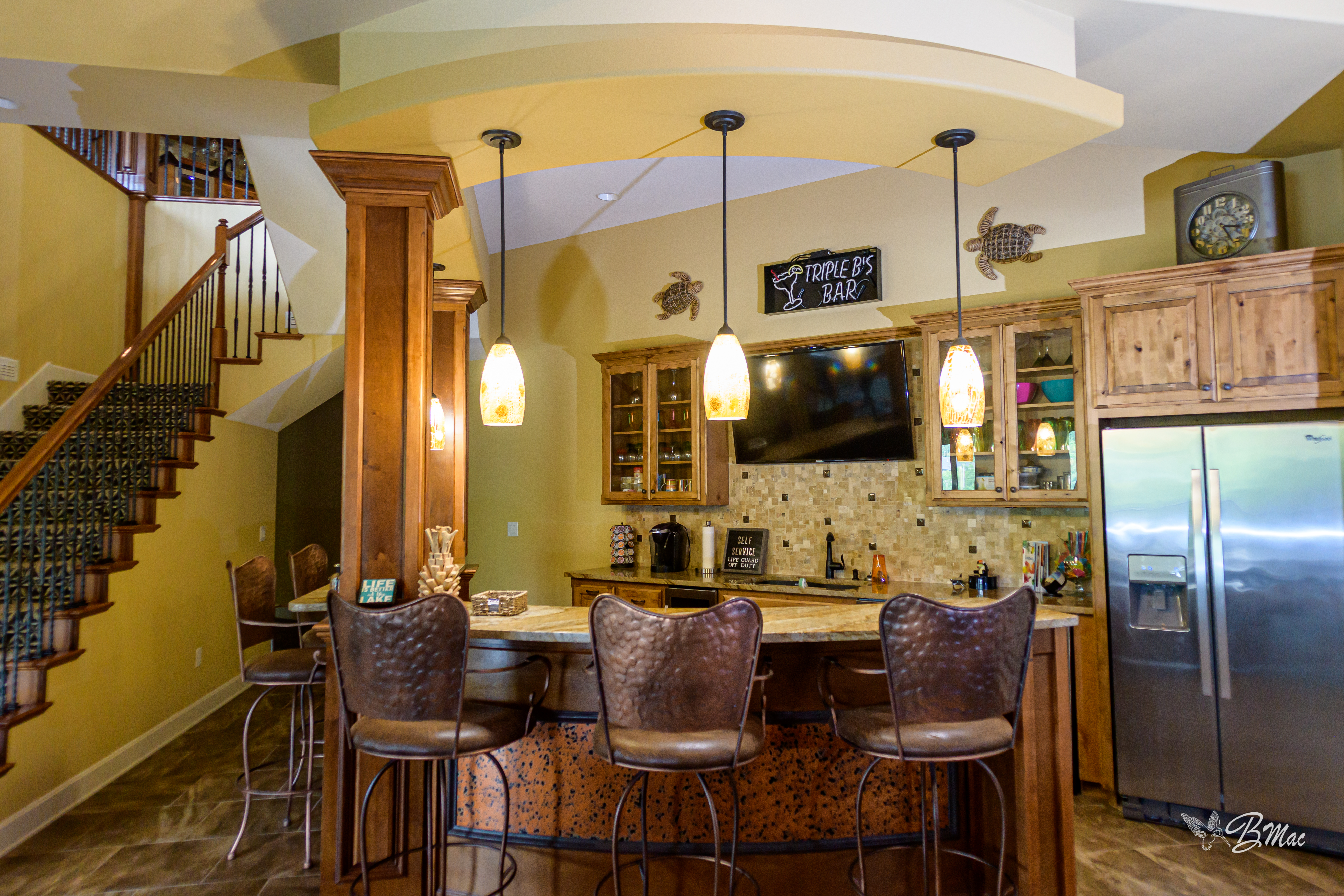 Custom kitchen bar area with pendant lighting and hammered copper bar front by Cloke Custom Homes