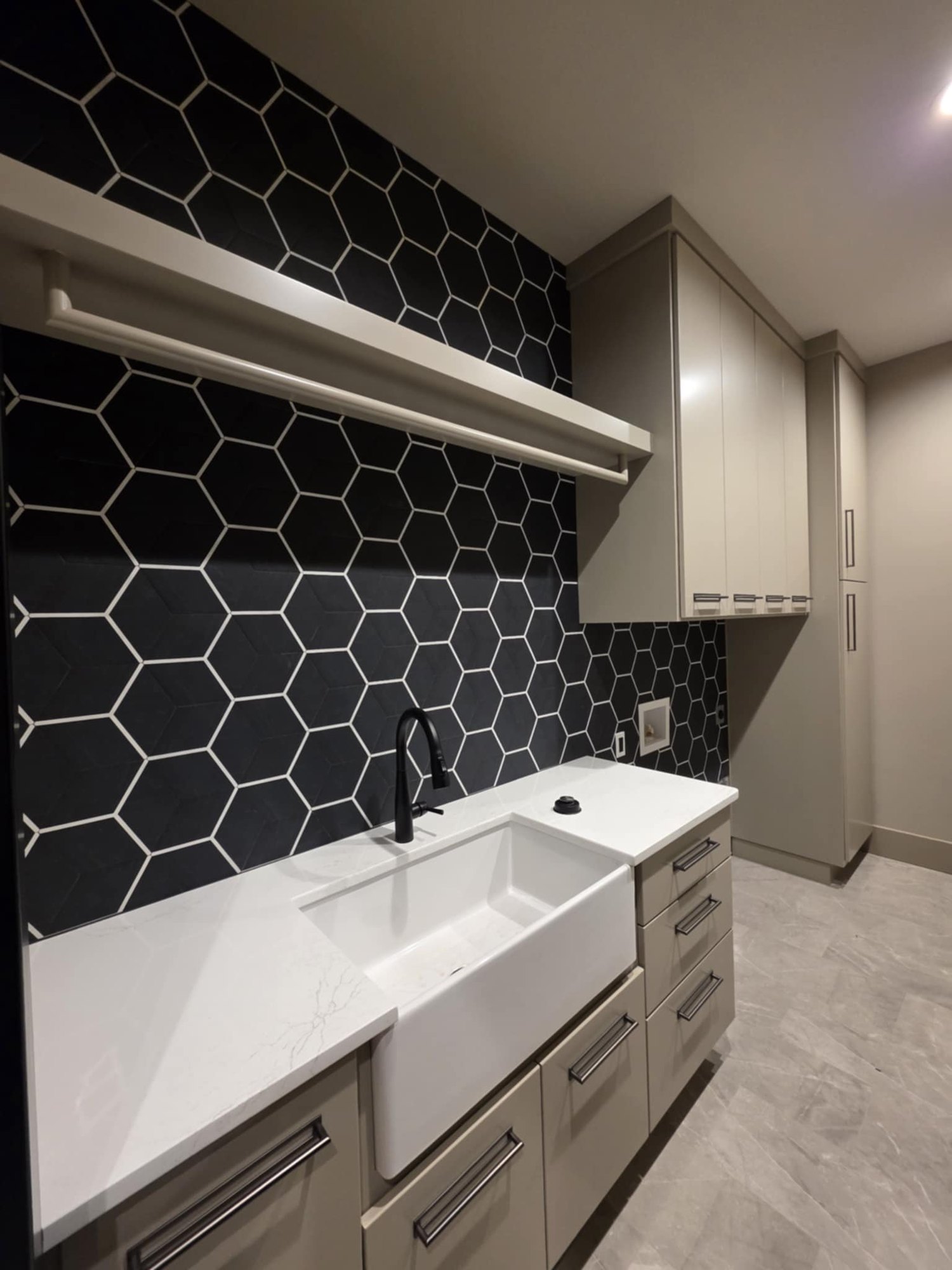 Contemporary kitchen with black hex tile and farmhouse sink by Cloke Custom Homes